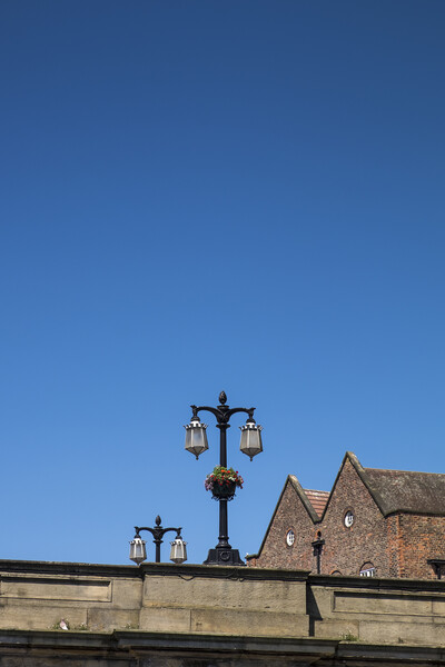 Street lamps against blue sky, York, Yorkshire,  Picture Board by Phil Crean