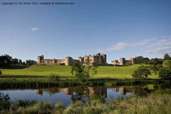 Alnwick Castle reflected in the River Aln Picture Board by Jim Jones