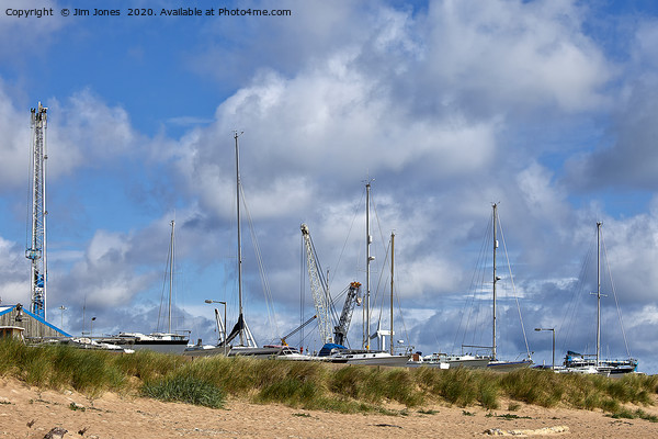 Yachts and Cranes behind the dunes Picture Board by Jim Jones