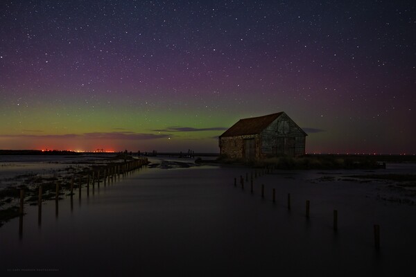 The Northern lights over the old coal barn at Thornham  Picture Board by Gary Pearson