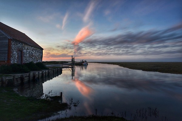 Reflections of sunset Thornham harbour Picture Board by Gary Pearson