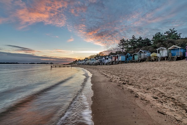 Beach huts at sunrise on beautiful Wells beach Picture Board by Gary Pearson