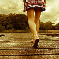 Buy canvas prints of Lady with a perfect figure walking on a jetty by Jonny Essex