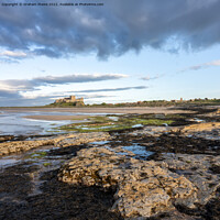 Buy canvas prints of Bamburgh Castle from Harkness Rocks sunset elevated by Graham Moore
