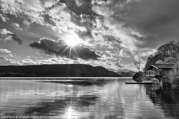 Ullswater boathouse with sun flare monochrome Picture Board by Graham Moore