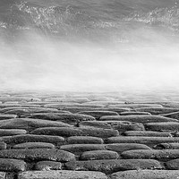Buy canvas prints of Wave splashes on cobbles monochrome by Graham Moore