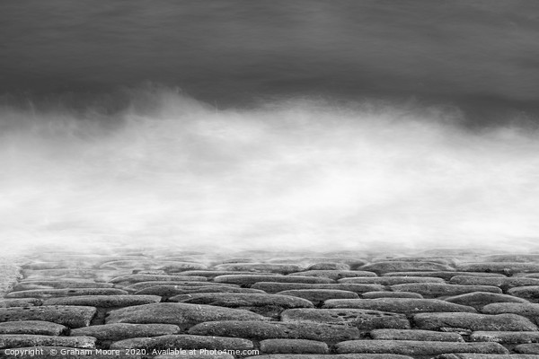 Waves on cobbles monochrome Picture Board by Graham Moore