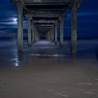 Buy canvas prints of  Under the pier at night by Paul Nichols